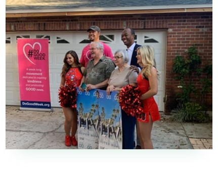 group of people posing near a # Do Good Week sign in the community