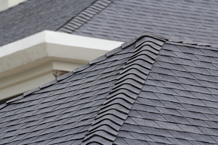 edge of Roof shingles on top of the house, dark asphalt tiles on the roof background